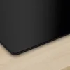Eine Hand, die die schwarze Glasoberfläche mit einem Tuch reinigt, um die Pflegeleichtigkeit hervorzuheben