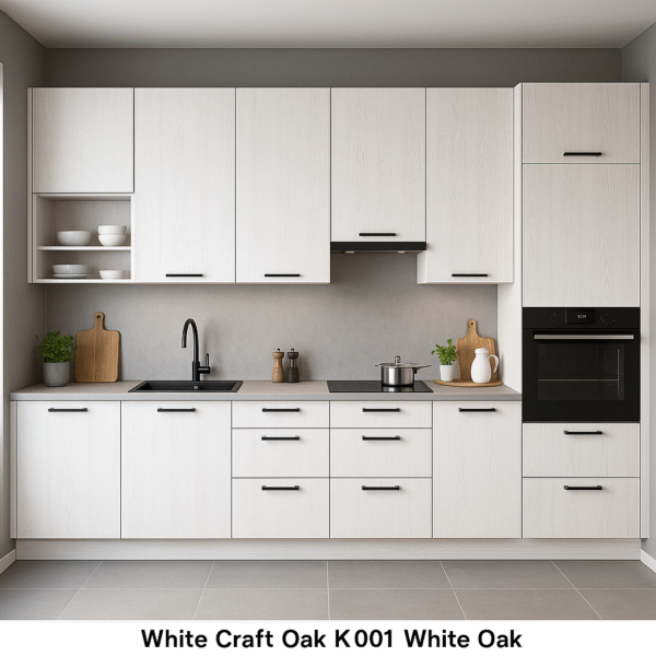 Moderne Einbauküche mit matten Fronten in White Craft Oak K001 Dekor, schwarzen Griffen, integriertem Backofen und minimalistischer Ausstattung vor neutraler grauer Wand.